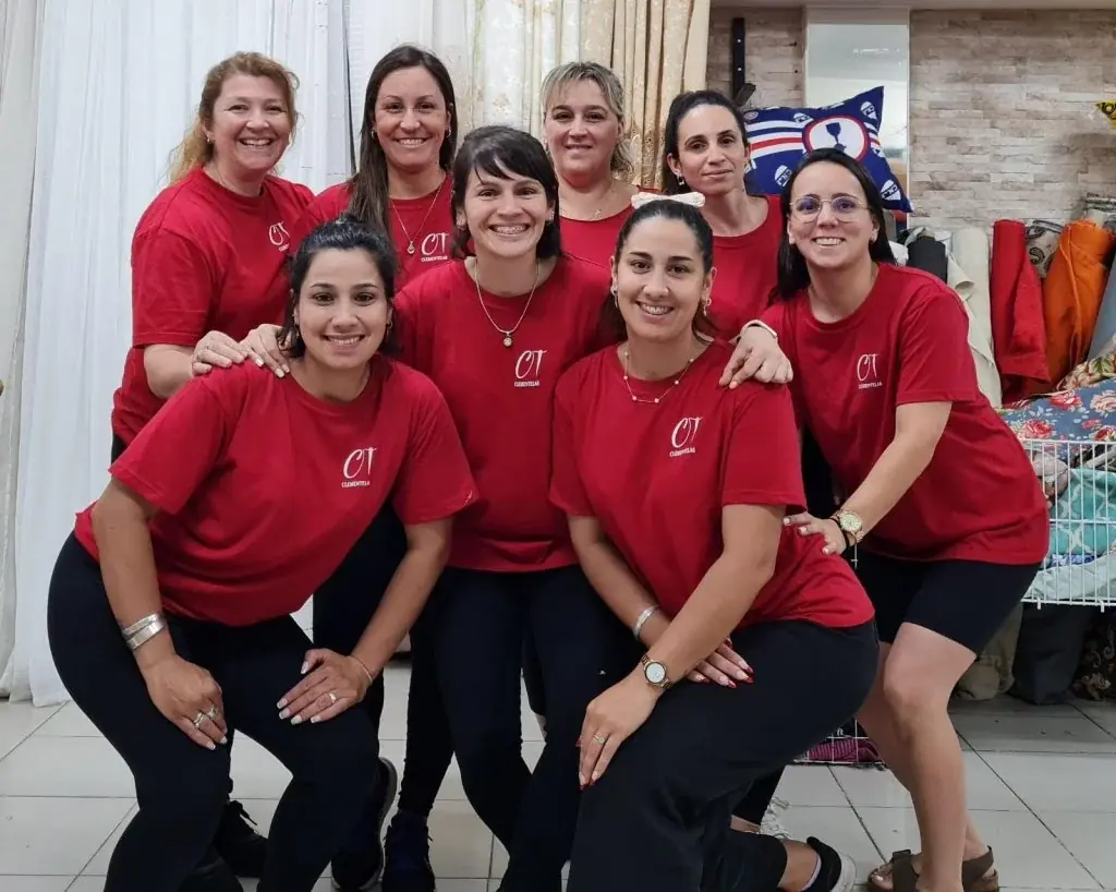 Nueve integrantes del equipo de Clementelas con remeras rojas con el logo CT, sonriendo en el local