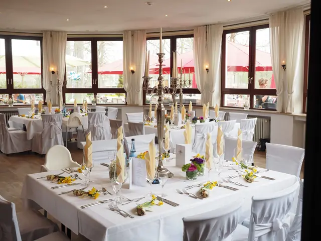 Salón de fiesta con mesas largas de mantel blanco y servilletas amarillas